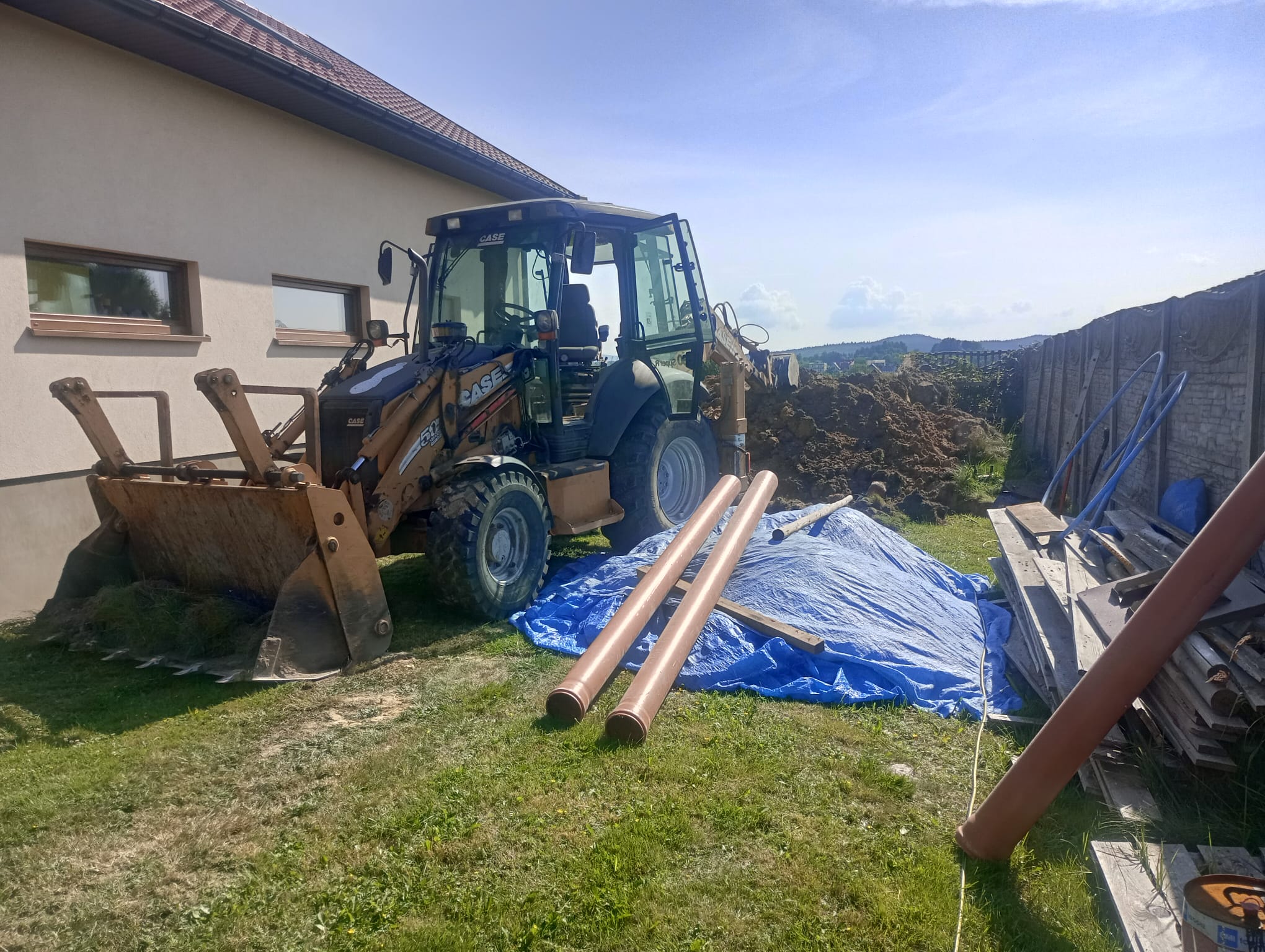 Koparka przy domu Kielce - prace instalacyjne i roboty ziemne przy budynku mieszkalnym
